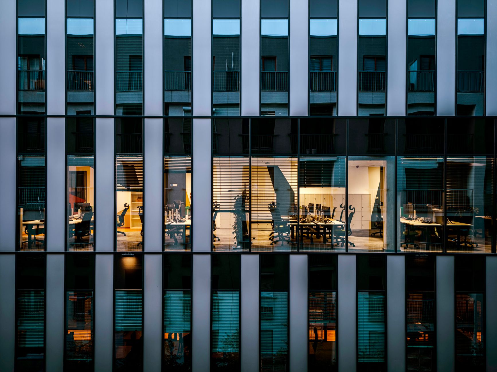 Lit office windows after dark, the kind of room where an archive is kept